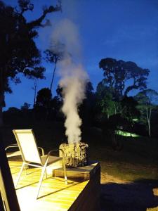 a chair and a heater with smoke coming out of it at Chale Pepê in Campo Alegre