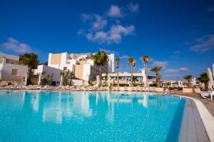 ein großer Swimmingpool vor einem Ferienresort in der Unterkunft Salini Resort in St Paul's Bay
