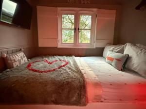 a bedroom with a bed with a heart on it at Poachers Hut at Keepers Cottage - Hot Tub & Pizza Oven - Trossachs in Port of Menteith