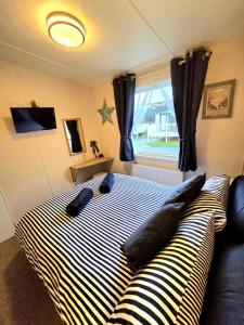 a bedroom with a striped bed and a window at The Crab Shack in Tywardreath +35 photos