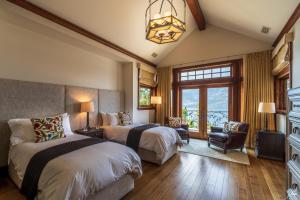 a bedroom with two beds and a chandelier at Chateau Okanagan in Kelowna
