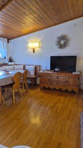 a living room with a table and a large television at Apartment 5 Torri, parcheggio in garage in Cortina dʼAmpezzo +19 photos