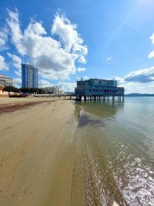 a beach with a pier and a building in the water at Oltremare in Follonica