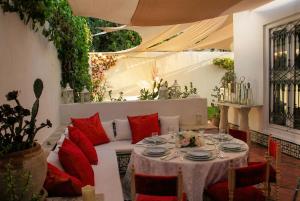 a patio with a white couch and a table with red pillows at Dar Esma in Tunis