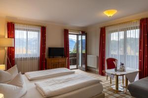 a hotel room with two beds and a television at Panoramahotel Kühbergalp in Gunzesried