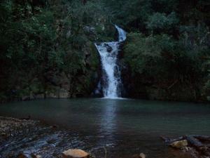 a waterfall in the middle of a pool of water at Pousada Germânia em Paraíso do Sul RS in Paraíso do Sul