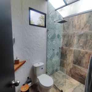 a bathroom with a toilet and a shower at Ecolodge La Corocora in Monterrey