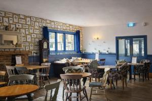 a restaurant with tables and chairs in a room at The Milford Arms in Hounslow