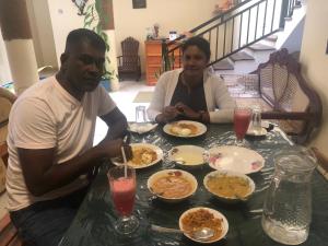 a man and a woman sitting at a table with food at MALWATHTHA MOUNT VILLA KANDY in Kandy