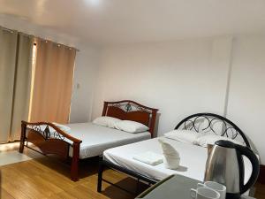 a small room with two beds and a table at Alona Chrisah Apartelle in Panglao Island