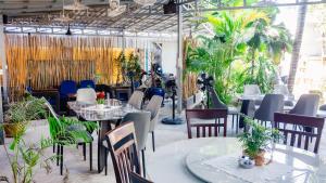 a restaurant with tables and chairs and plants at Villa Blue Lagoon in Sihanoukville