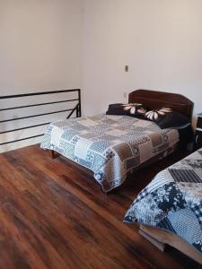 a bedroom with two beds and a wooden floor at La Fábula-Naranja in Copacabana