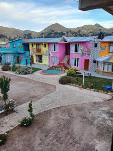 a row of colorful houses with mountains in the background at La Fábula-Naranja in Copacabana +6 photos