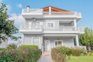 a white house with a balcony on top at Villa Luna in Káto Ássos +67 photos
