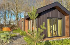 a small house with a black roof and a patio at Sernets Recreatie Chalet 111 in Oud-Gastel