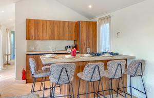 a kitchen with a island with bar stools at Sernets Recreatie Chalet 111 in Oud-Gastel