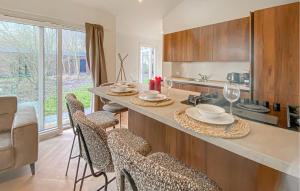 a kitchen with a counter with a table and chairs at Sernets Recreatie Chalet 111 in Oud-Gastel