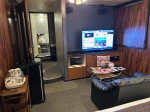 a living room with a couch and a tv at Hotel LAGNA in Moriyama +20 photos