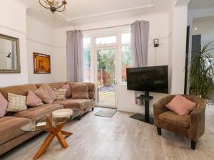 a living room with a couch and a tv at Broadgreen in Liverpool