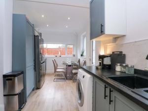 a kitchen with a sink and a table with chairs at Broadgreen in Liverpool