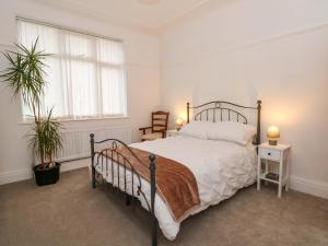 a bedroom with a bed and two potted plants at Broadgreen in Liverpool
