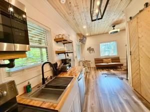 a kitchen with a sink and a stove top oven at New Tiny cabin Hot tub Firepit Fenced yard in Sevierville +23 photos