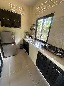 a kitchen with a stainless steel refrigerator and a window at Mina House in Thong Nai Pan Yai