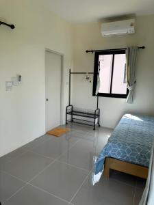 a bedroom with a bed and a window at Mina House in Thong Nai Pan Yai