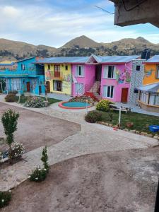 a row of colorful houses with mountains in the background at La Fábula-Verde Limón in Copacabana