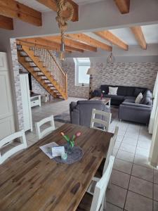 ein Esszimmer und ein Wohnzimmer mit einem Holztisch in der Unterkunft Haus Max in Dornum