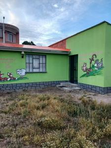 a green building with drawings on the side of it at La Fábula-Verde Limón in Copacabana +3 photos