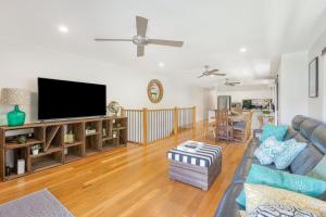 a living room with a couch and a flat screen tv at Palmy Villa in Gold Coast