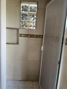 a bathroom with a shower and a window at Cabaña El real in Cedro