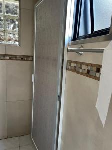 a shower door in a bathroom with a window at Cabaña El real in Cedro
