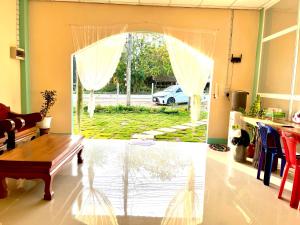 a living room with a door open to a yard at RSP Hostel รักษ์สุพรโฮสเทล in Ban Hua Thung