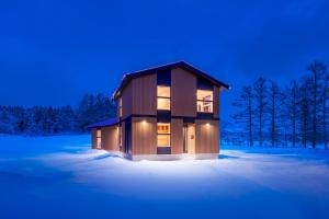 a house in the snow with lights on at Sakuraya in Hakuba