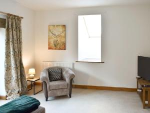 a living room with a chair and a window at Quarry Cottage in Penrith