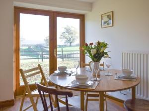 a dining room with a table and chairs and a window at Quarry Cottage in Penrith