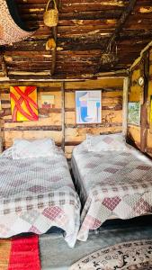 a bedroom with two beds in a log cabin at Cabaña Rústica Villa Alicia in Paipa