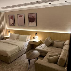 a hotel room with a bed and a couch at نسيم الحرم in Ash Shishah