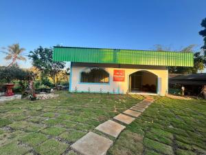 a building with a green roof and a yard at RSP Hostel รักษ์สุพรโฮสเทล in Ban Hua Thung