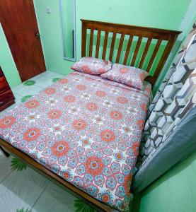 a bedroom with a bed with a floral comforter and pillows at mango suites in Portsmouth