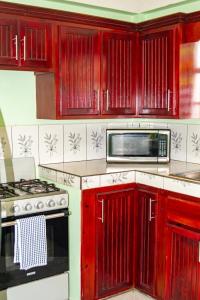 a kitchen with red cabinets and a microwave at mango suites in Portsmouth