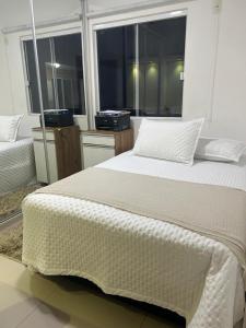 a large bed in a room with a large window at Casa de lazer e tranquilidade in Tramandaí