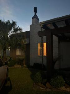 a house with a light in the window at Casa de lazer e tranquilidade in Tramandaí
