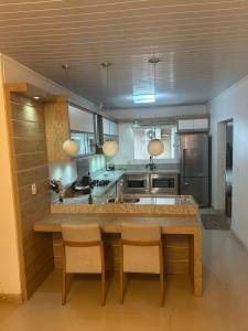 a kitchen with a table and some chairs in it at Casa de lazer e tranquilidade in Tramandaí