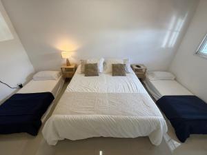 two beds in a small room with two lamps at Cocheras Ezeiza Victoria in Ezeiza