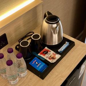 a tray with a tea kettle and bottles of water at نسيم الحرم in Ash Shishah