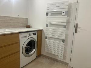 a kitchen with a washing machine in a kitchen at Maison Familiale - 7 personnes - Parking privé & Jardin - Disney 24 min in Tournan-en-Brie