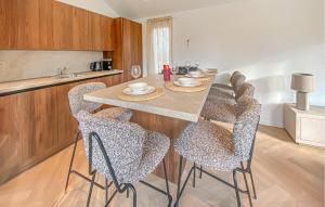 a kitchen with a table with chairs and a counter at Sernets Recreatie Chalet 112 in Oud-Gastel